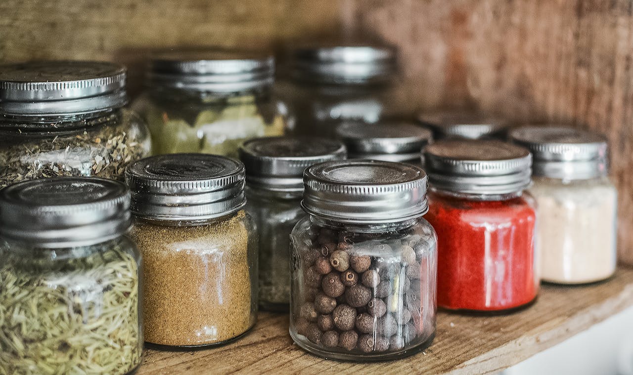 who-we-are Close-up of assorted spice jars with various herbs on a kitchen shelf, showcasing colorful culinary ingredients.